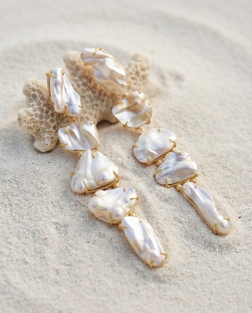 Drop Pearl earrings on a sandy surface